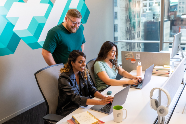 Three Sprout employees working and collaborating together in one of our open-plan office areas.