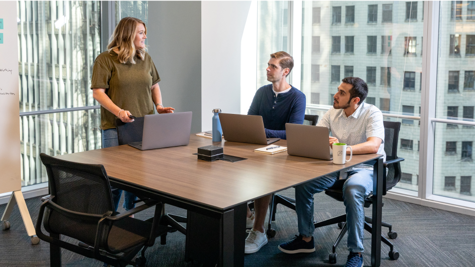 Three team members deep in discussion during a meeting.
