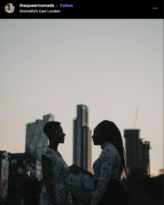 Two people stand facing each other at sunset in Shoreditch, East London, with city skyscrapers in the background.